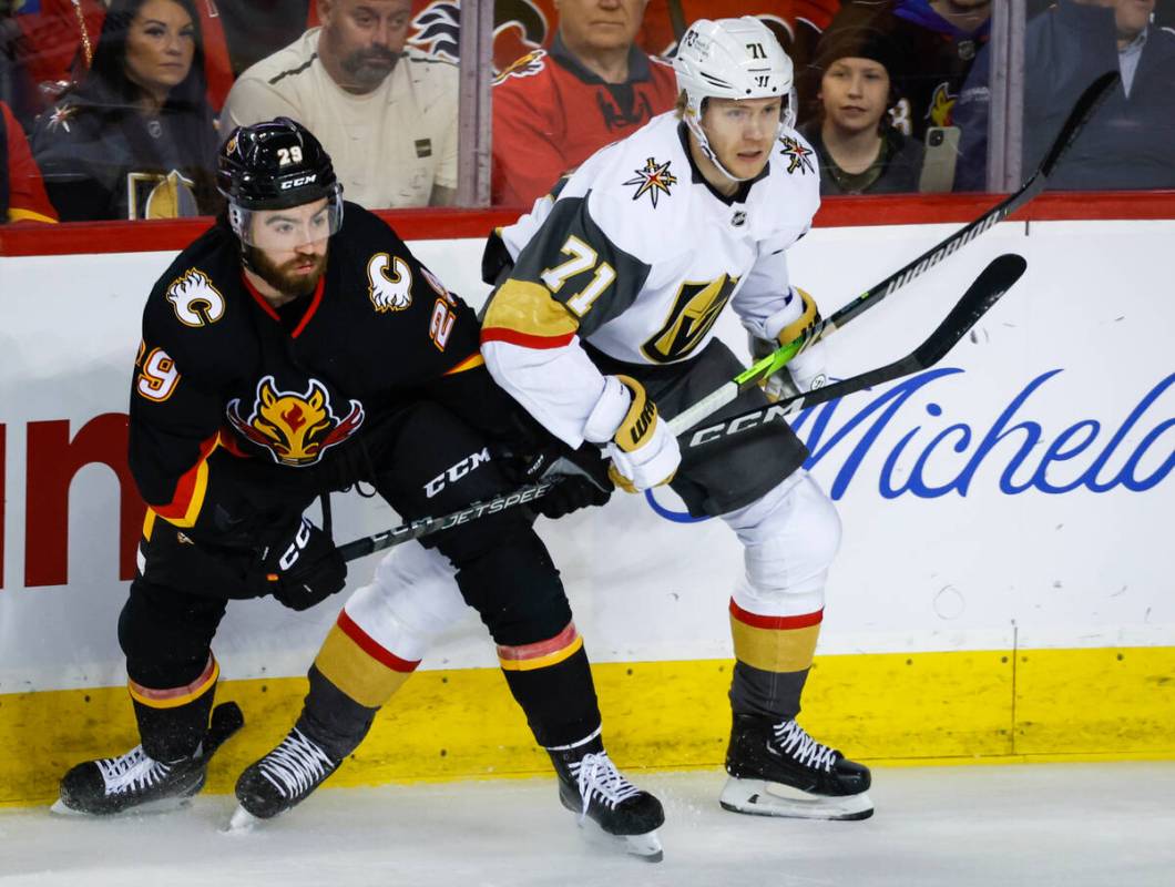 Vegas Golden Knights forward William Karlsson, right, is checked by Calgary Flames forward Dill ...