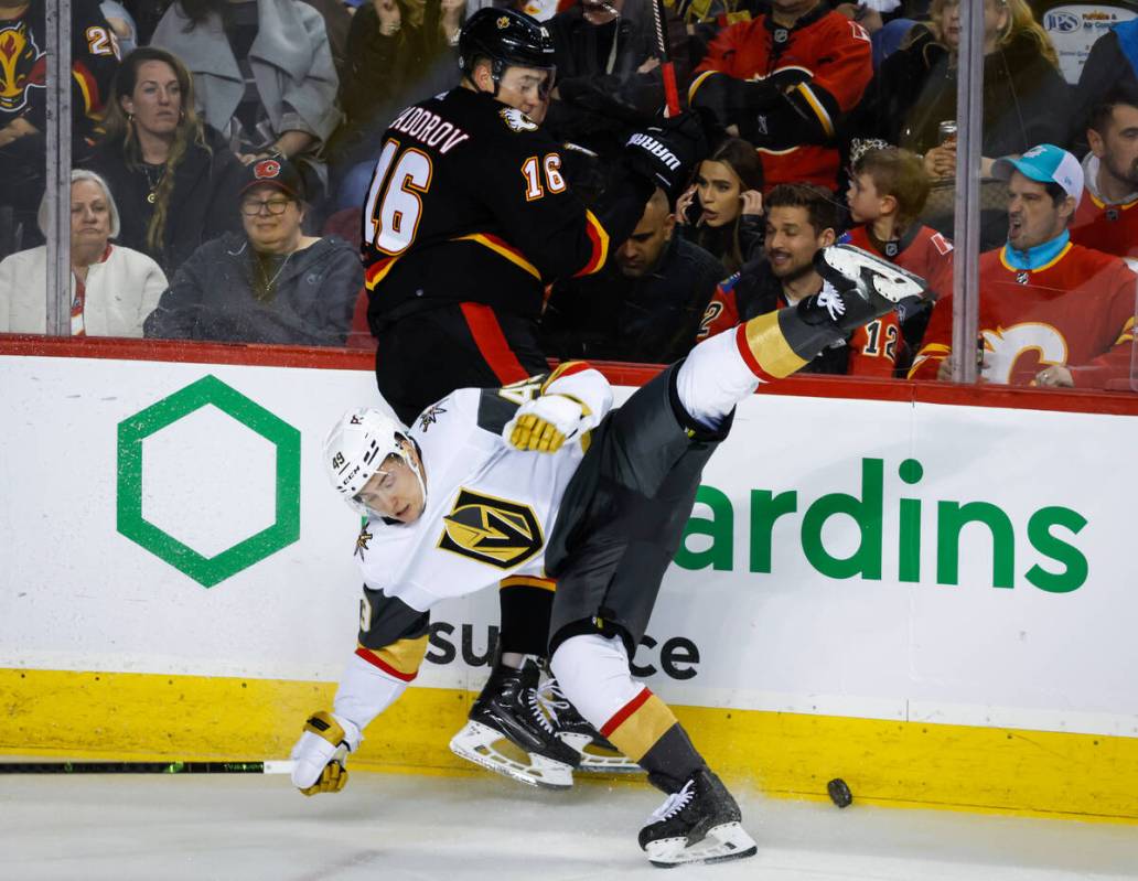 Vegas Golden Knights forward Ivan Barbashev, bottom, is checked by Calgary Flames defenseman Ni ...