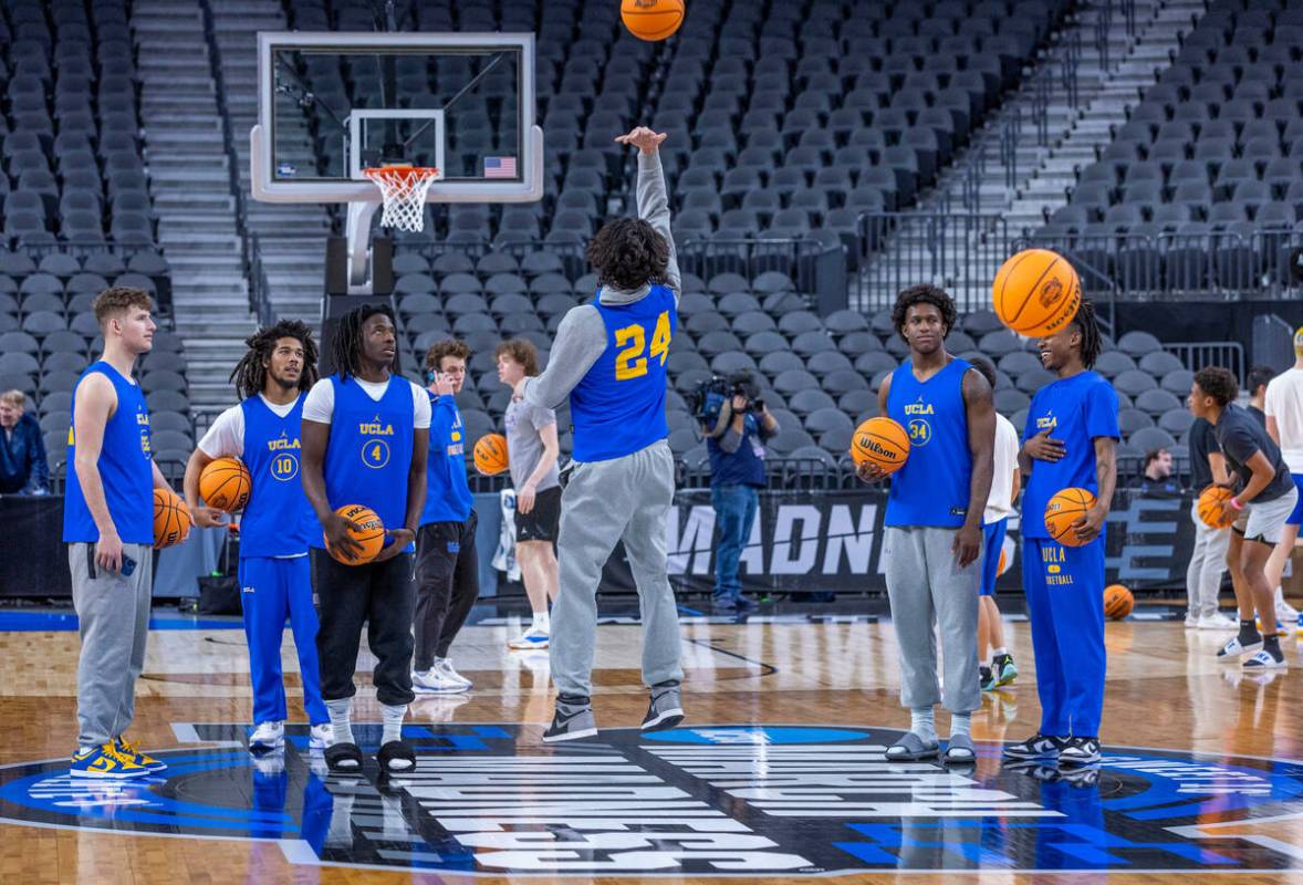 UCLA forward Jaime Jaquez Jr., center, tosses a half-court shot backwards as teammates watch du ...