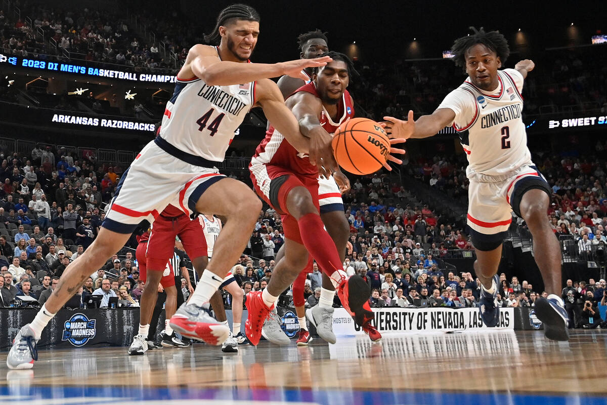 UConn's Andre Jackson Jr. (44) and Tristen Newton (2) reach for the ball against Arkansas' Kama ...