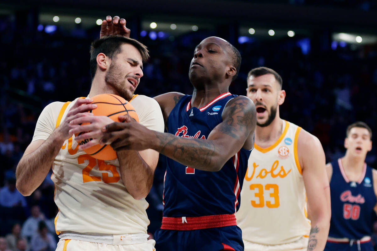 Tennessee guard Santiago Vescovi, left, and Florida Atlantic guard Johnell Davis reach for the ...