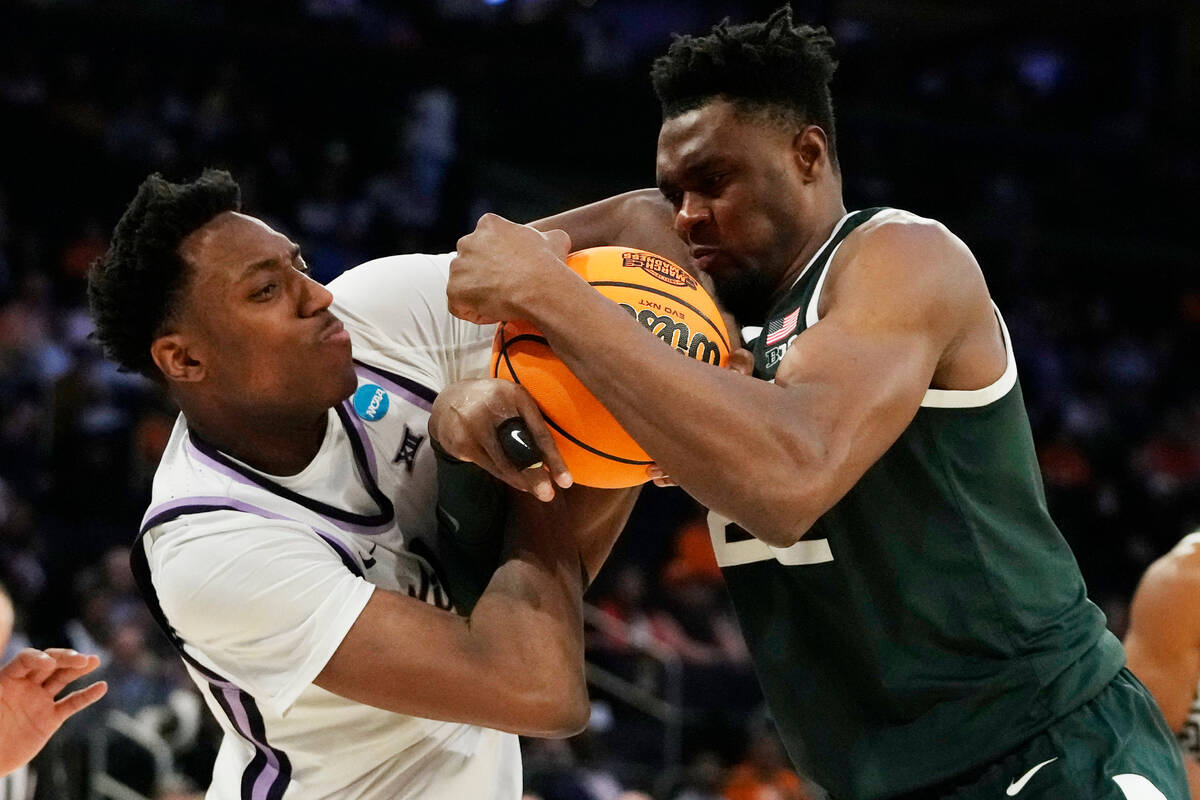 Kansas State forward Nae'Qwan Tomlin, left, and Michigan State center Mady Sissoko (22) reach f ...