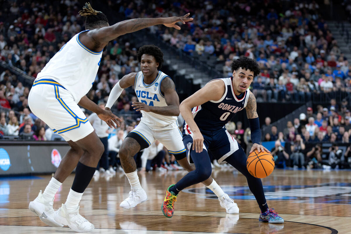 Gonzaga Bulldogs guard Julian Strawther (0) dribbles around UCLA Bruins forward Kenneth Nwuba, ...