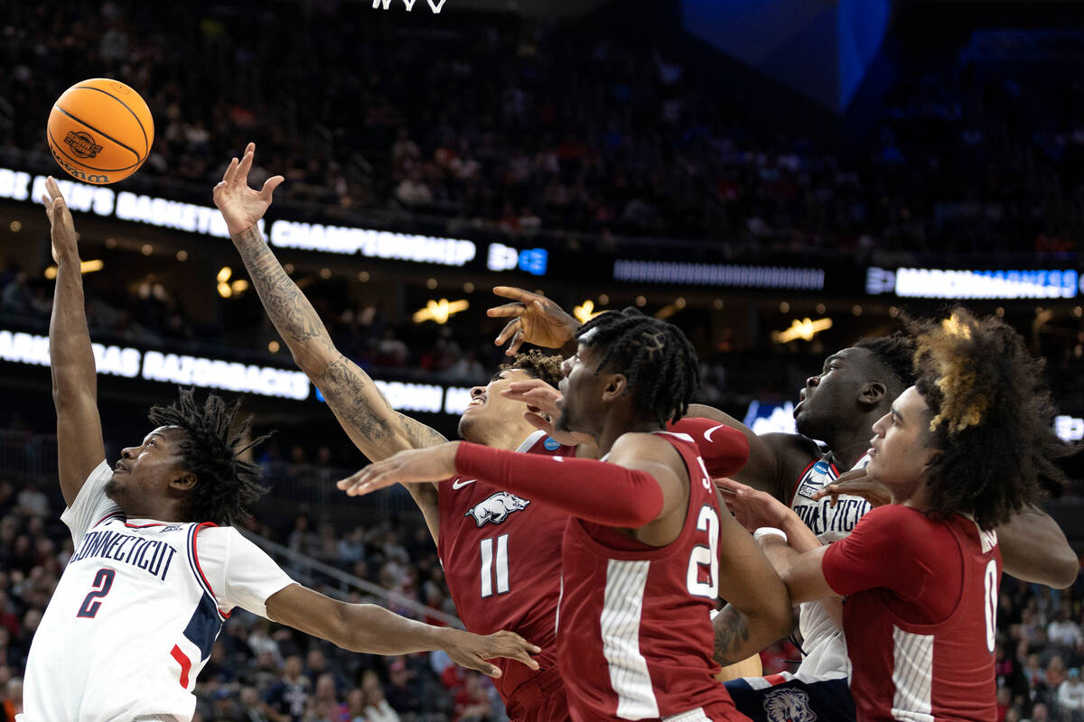 Connecticut Huskies guard Tristen Newton (2) and forward Adama Sanogo, second from right, jump ...