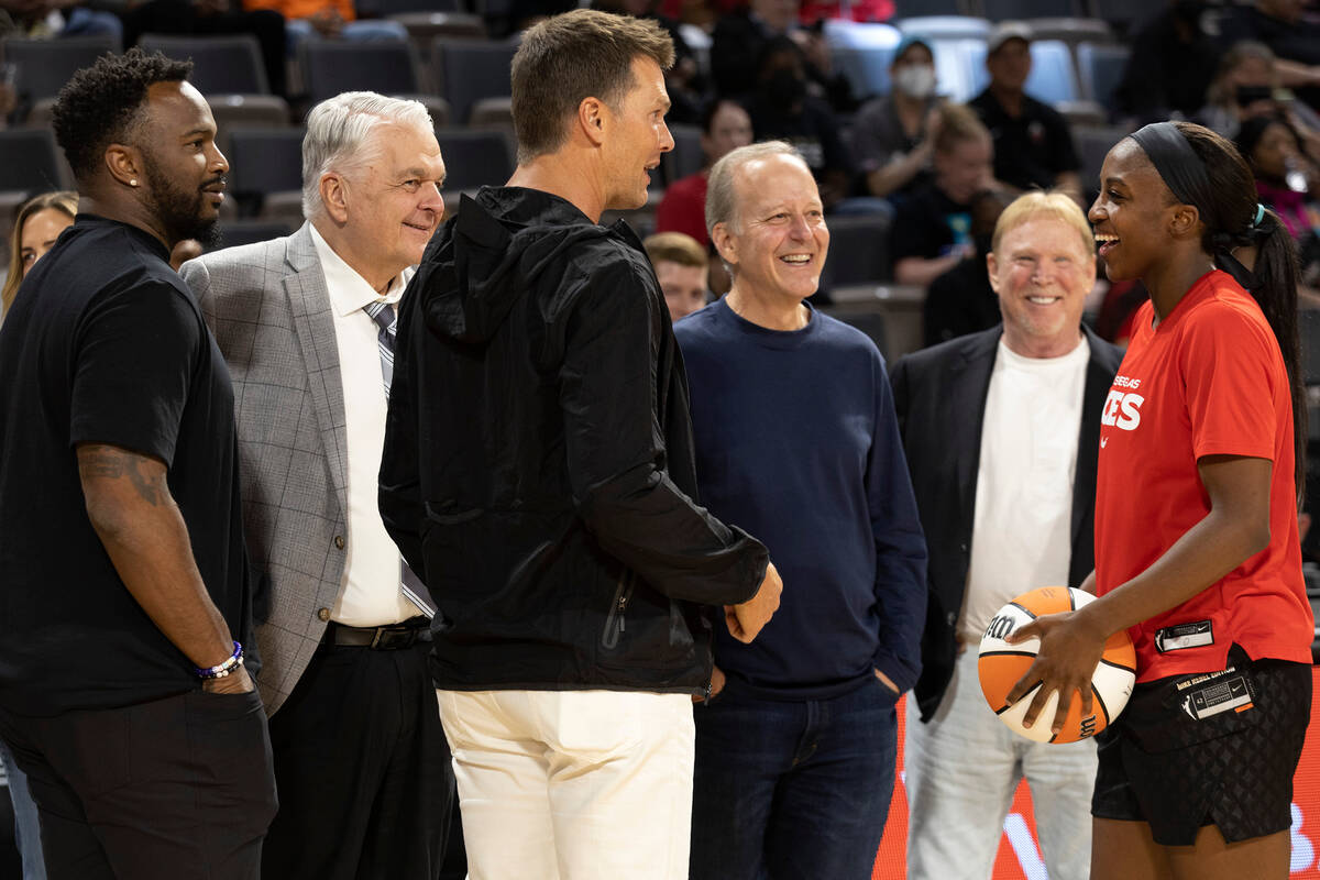 Las Vegas Aces guard Jackie Young (0) laughs with football quarterback Tom Brady, center, durin ...