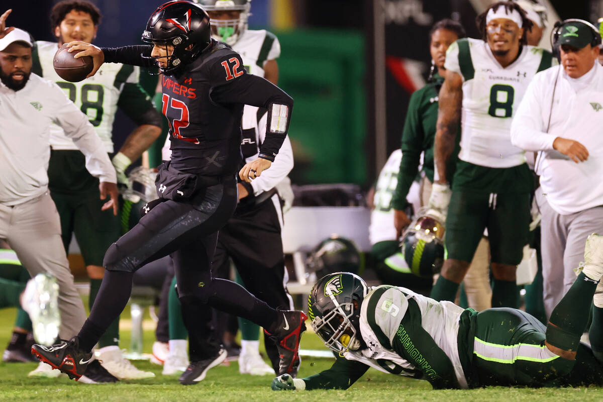 Vegas Vipers quarterback Luis Perez (12) runs the ball out of bounds while under pressure from ...