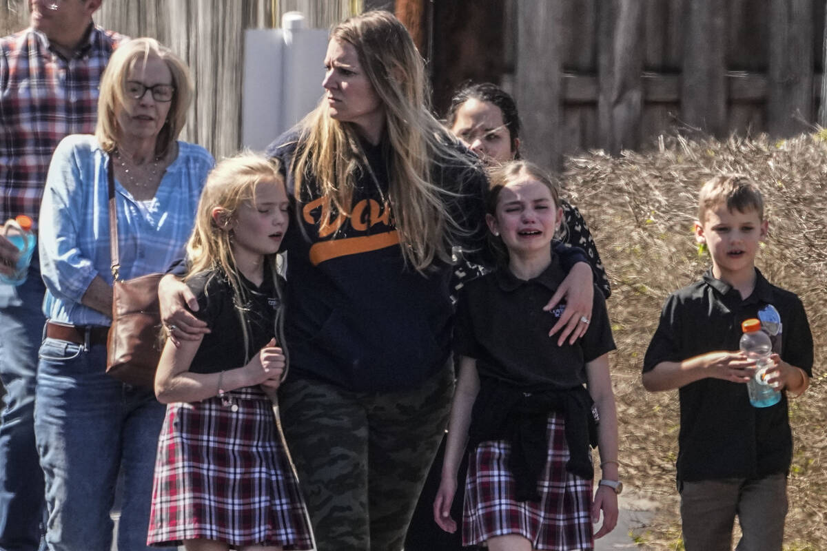 Children and a woman depart the reunification center at the Woodmont Baptist church after a sch ...