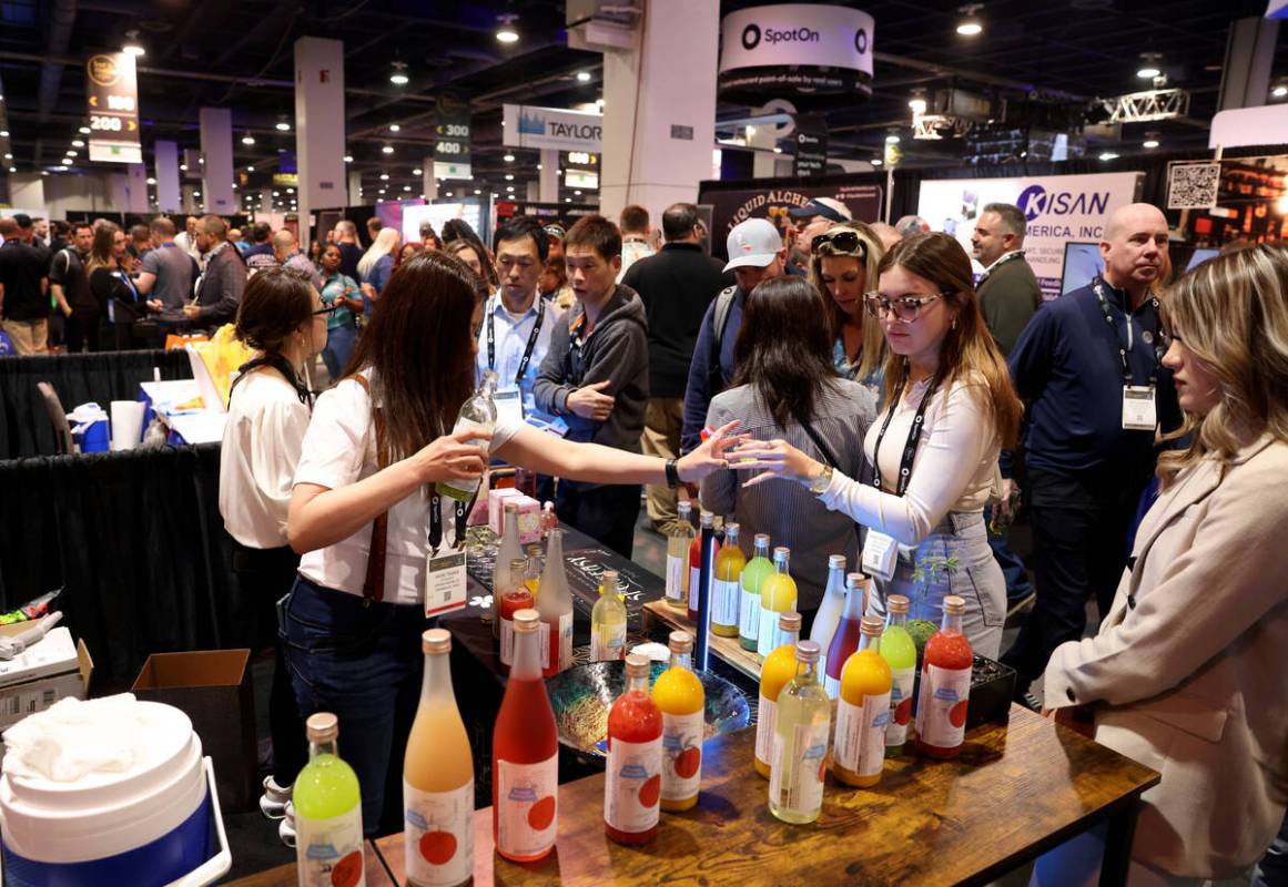 Kaori Tanaka with Kitaoka-Honten Co. from Japan, left, gives samples to conventioneers, includi ...