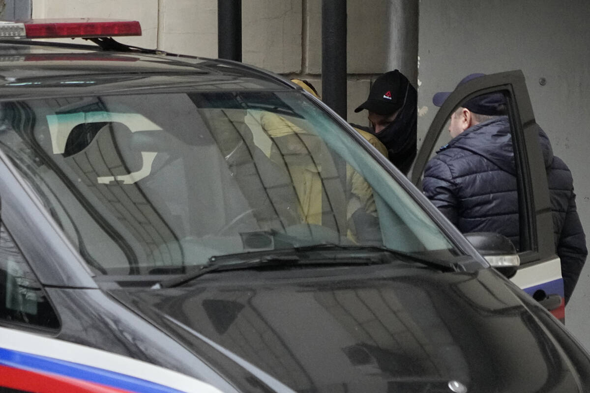 Reporter for the Wall Street Journal Evan Gershkovich, centre, is escorted by officers from the ...