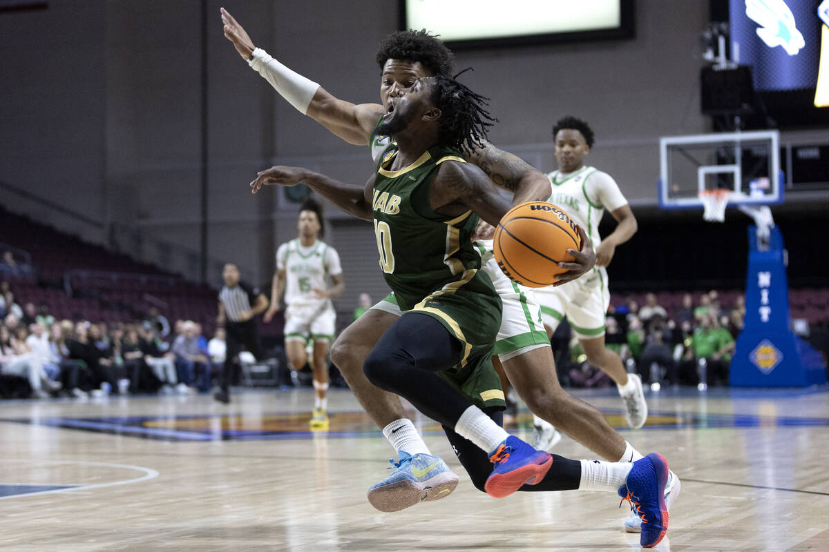 UAB Blazers guard Jordan Walker (10) drives around North Texas Mean Green guard Kai Huntsberry ...