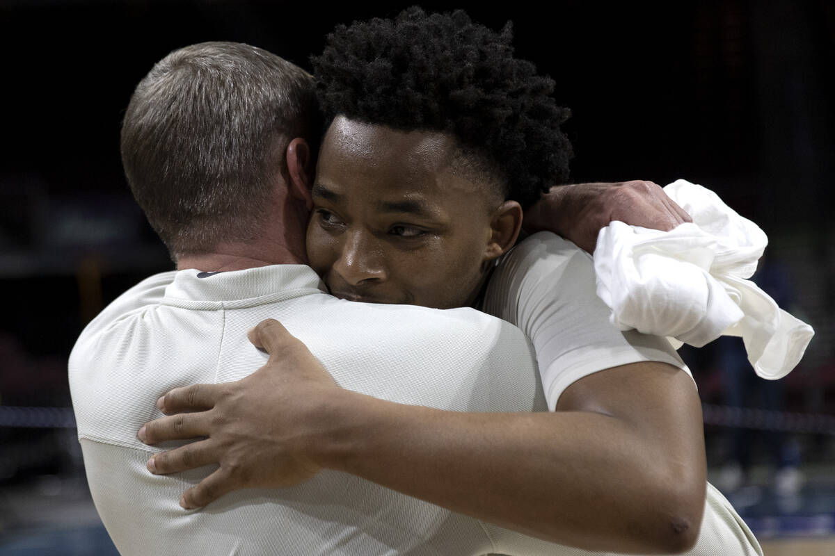 North Texas Mean Green guard Tylor Perry hugs associate head coach Ross Hodge after their team ...