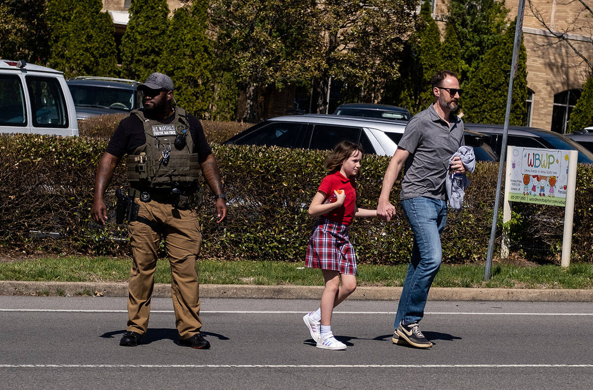 A parent walks with his child from Woodmont Baptist Church where children were reunited with th ...