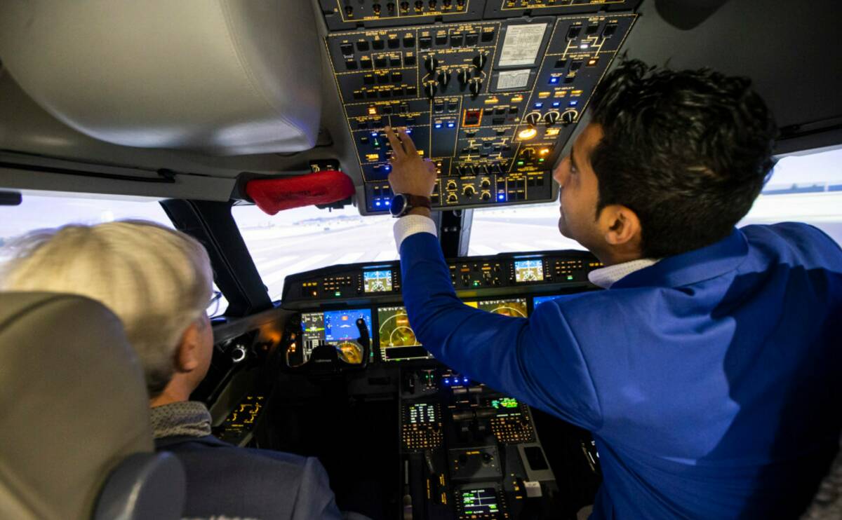 Arash Sadegh, training manager at CAE, right, shows off one of the full-flight simulators to Th ...