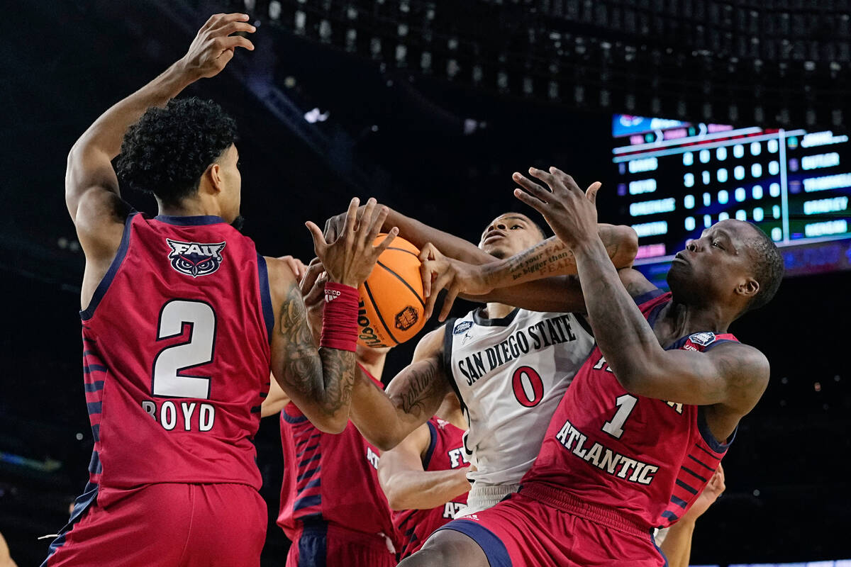 San Diego State forward Keshad Johnson drives to the basket between Florida Atlantic guard Nich ...