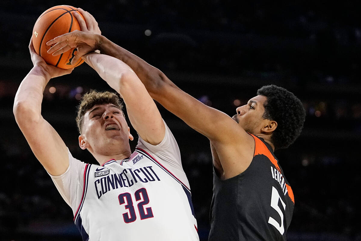 Miami guard Harlond Beverly fouls Connecticut center Donovan Clingan during the first half of a ...