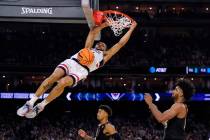 Connecticut guard Andre Jackson Jr. dunks the ball over Miami forward Norchad Omier, right, dur ...