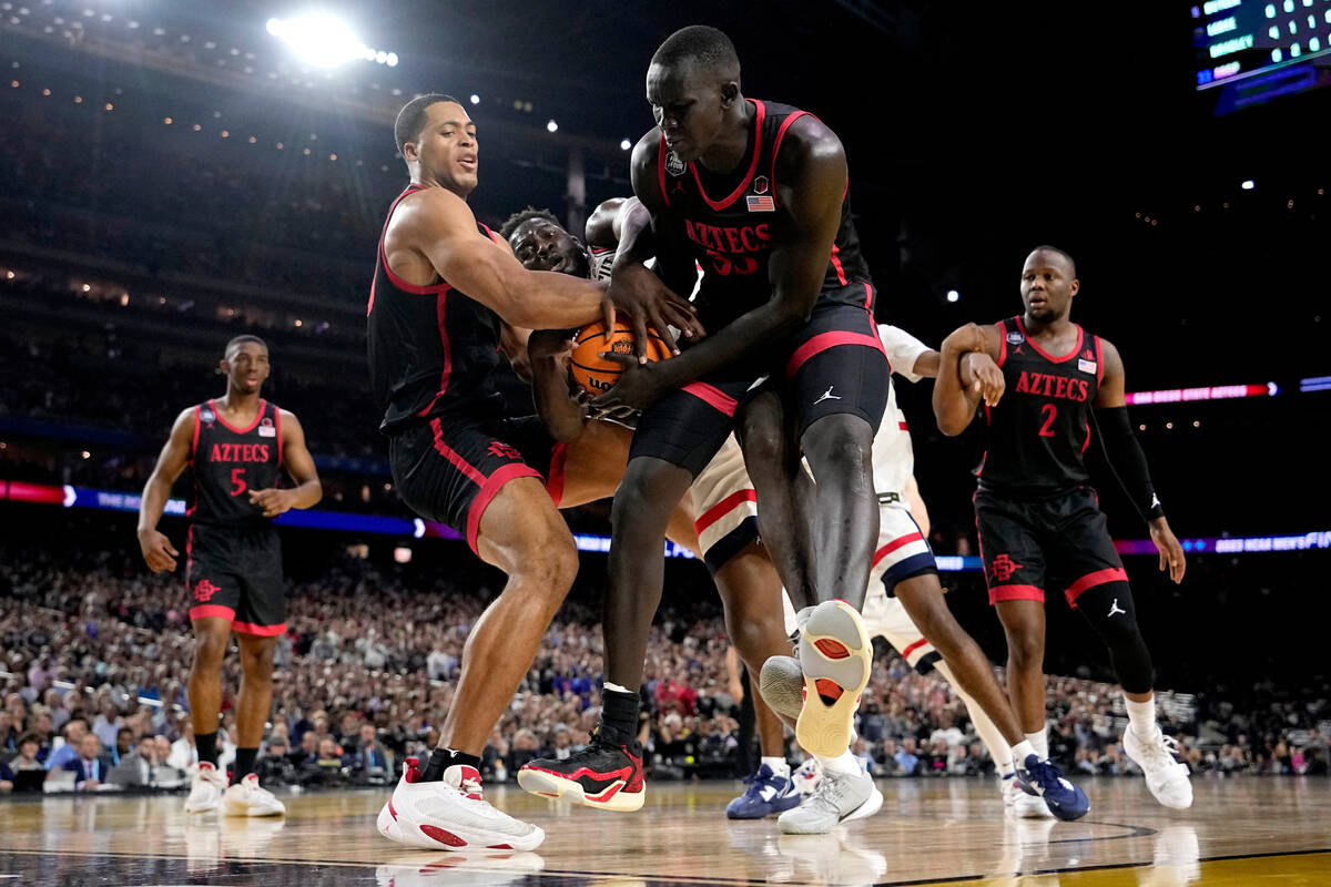 Connecticut forward Adama Sanogo, center, vies for the ball with San Diego State forward Jaedon ...