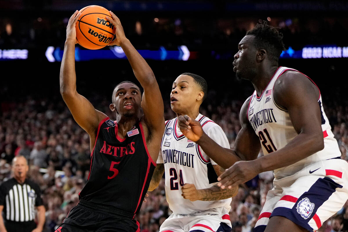 San Diego State guard Lamont Butler (5) drives as Connecticut guard Jordan Hawkins (24) defends ...