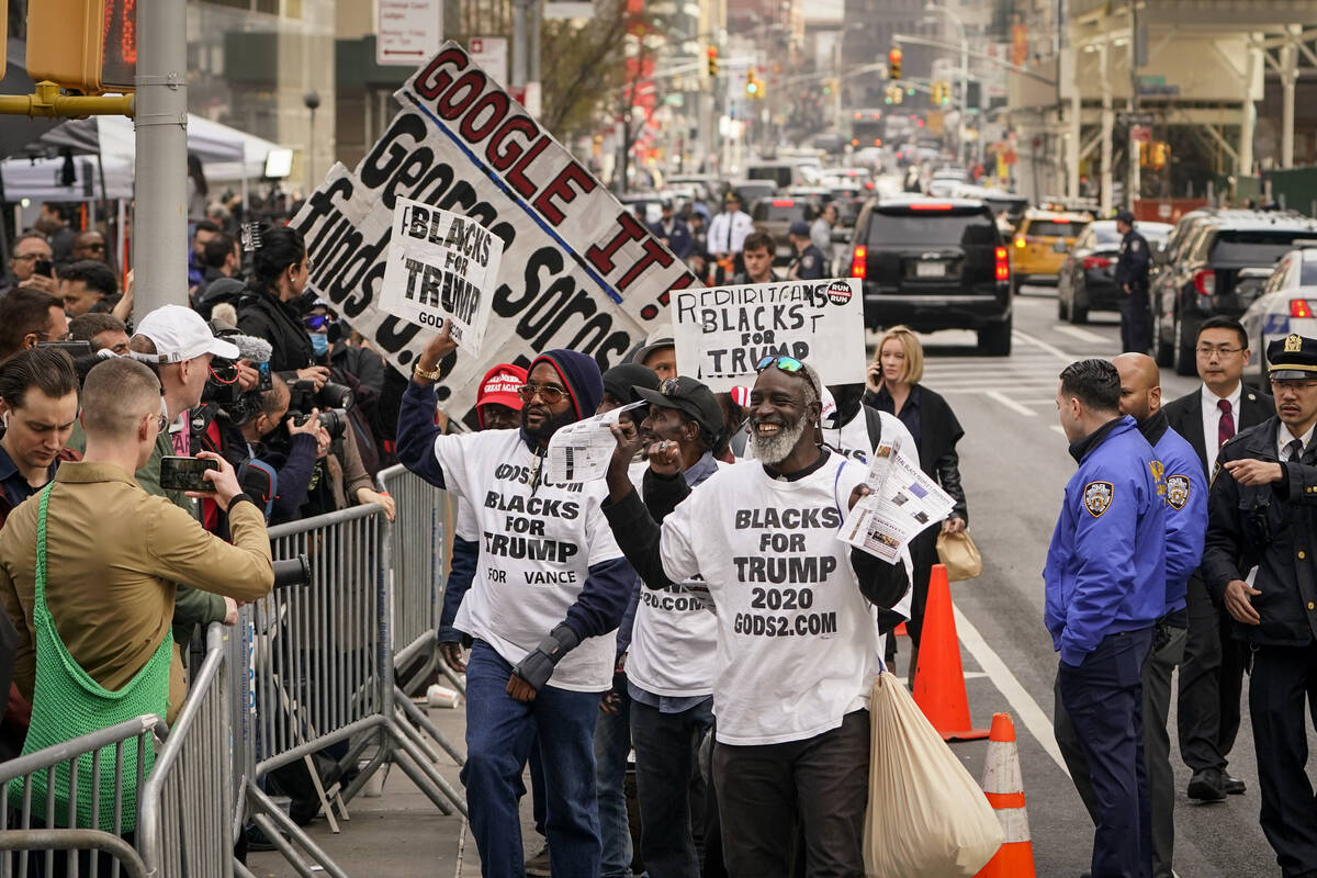 Supporters of Former President Donald Trump parade their signs in front of assembled media and ...