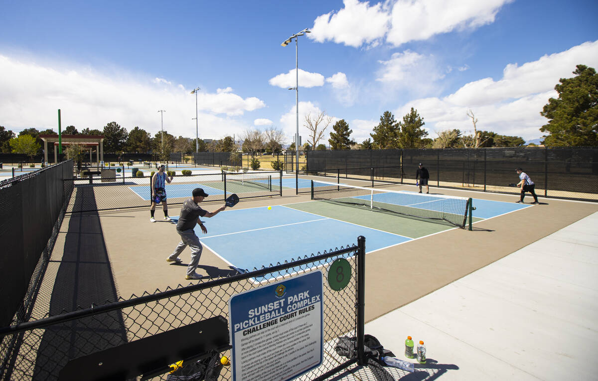 Steve Beckwith, of Henderson, second from left, swings at the ball while playing pickleball wit ...