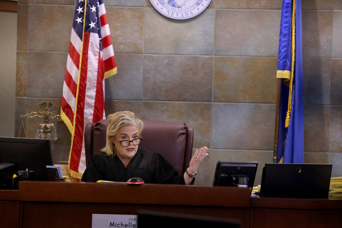 District Judge Michelle Leavitt speaks to former Clark County Administrator Robert Telles, who ...