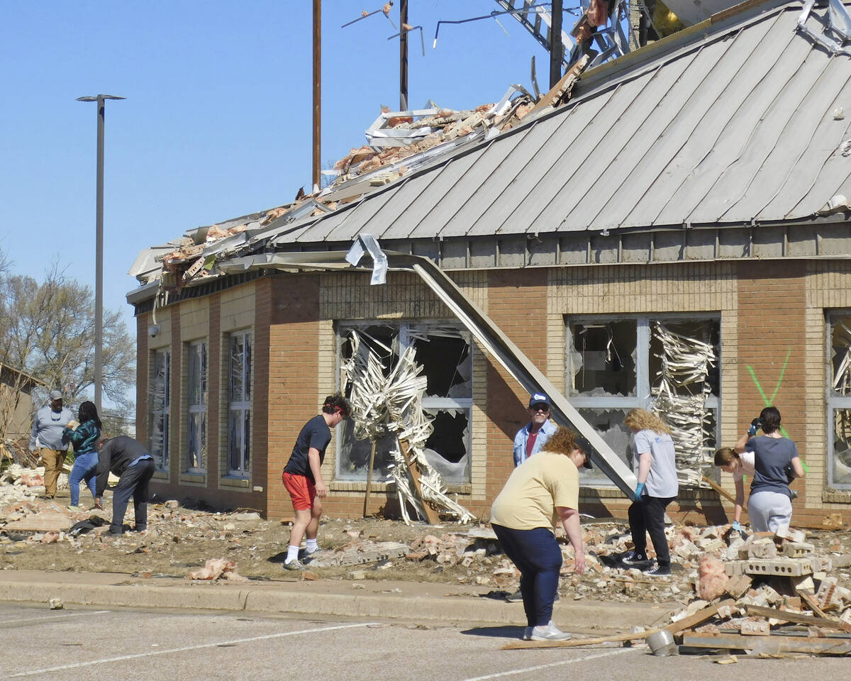 Volunteers clean up at Wynne High School, Saturday, April 1, 2023, near the front entrance of t ...