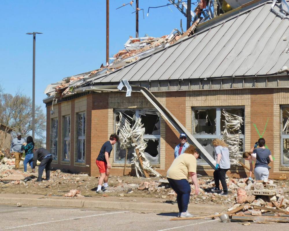 Volunteers clean up at Wynne High School, Saturday, April 1, 2023, near the front entrance of t ...