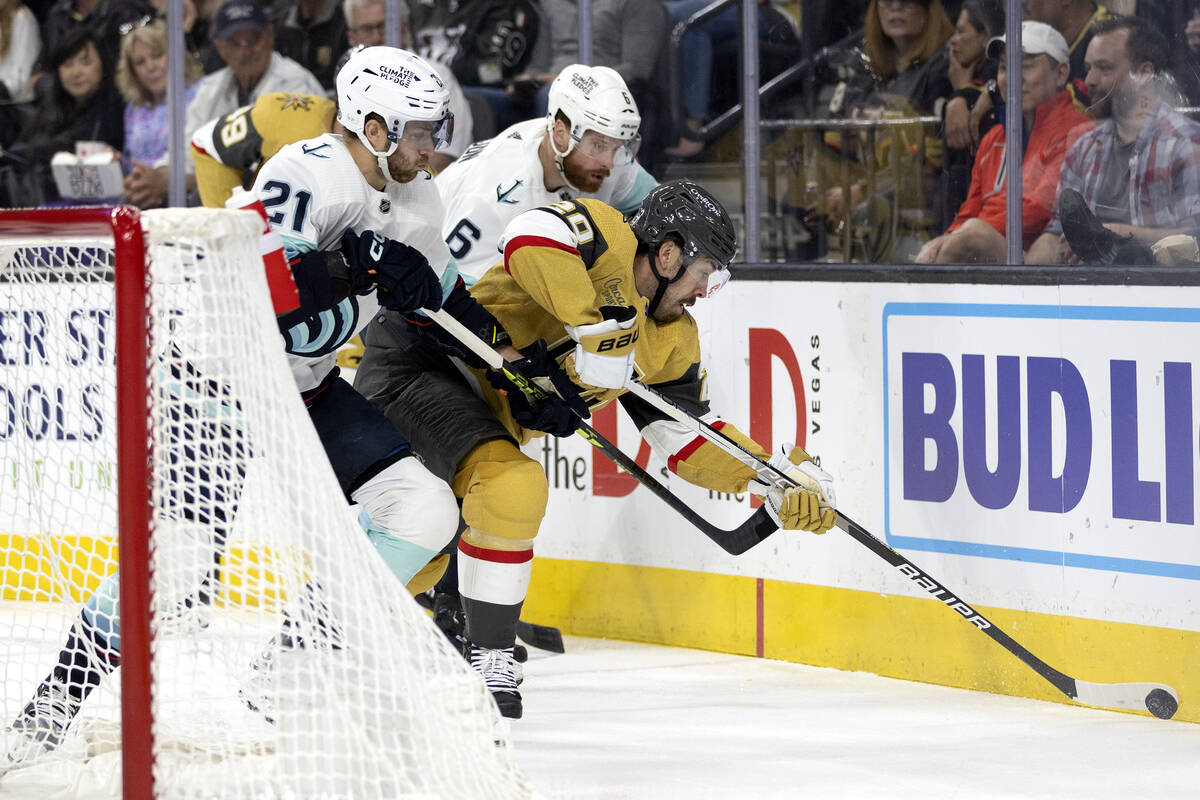 Golden Knights center Chandler Stephenson (20) battles for the puck with Seattle Kraken center ...