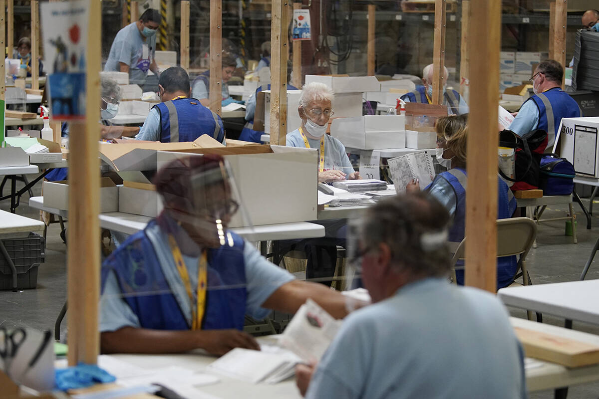 FILE - In this June 9, 2020 file photo election workers process mail-in ballots during a nearly ...