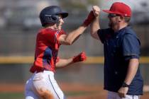 Coronado’s Evan Festa bumps fists with head coach Garrett Smith after scoring a home run ...