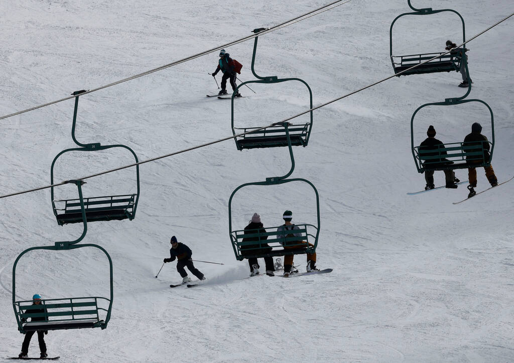 Skiers and snowboarders enjoy the slope as people ride chairlifts Monday, Dec. 26, 2022, at the ...