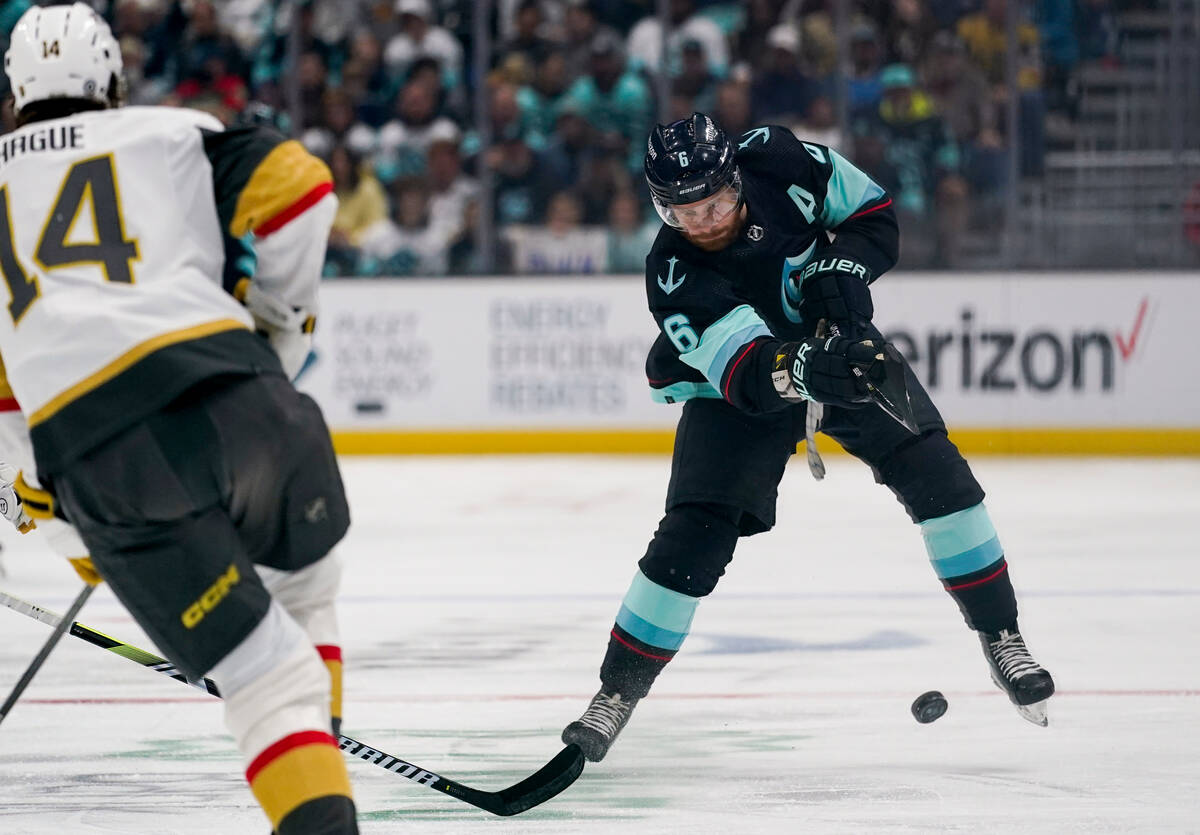 Seattle Kraken defenseman Adam Larsson (6) sends the puck down ice past Vegas Golden Knights de ...