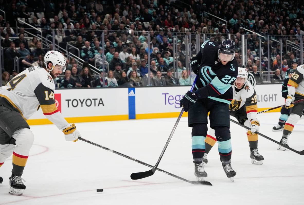 Seattle Kraken defenseman Carson Soucy (28) tries to shoot past Vegas Golden Knights defenseman ...