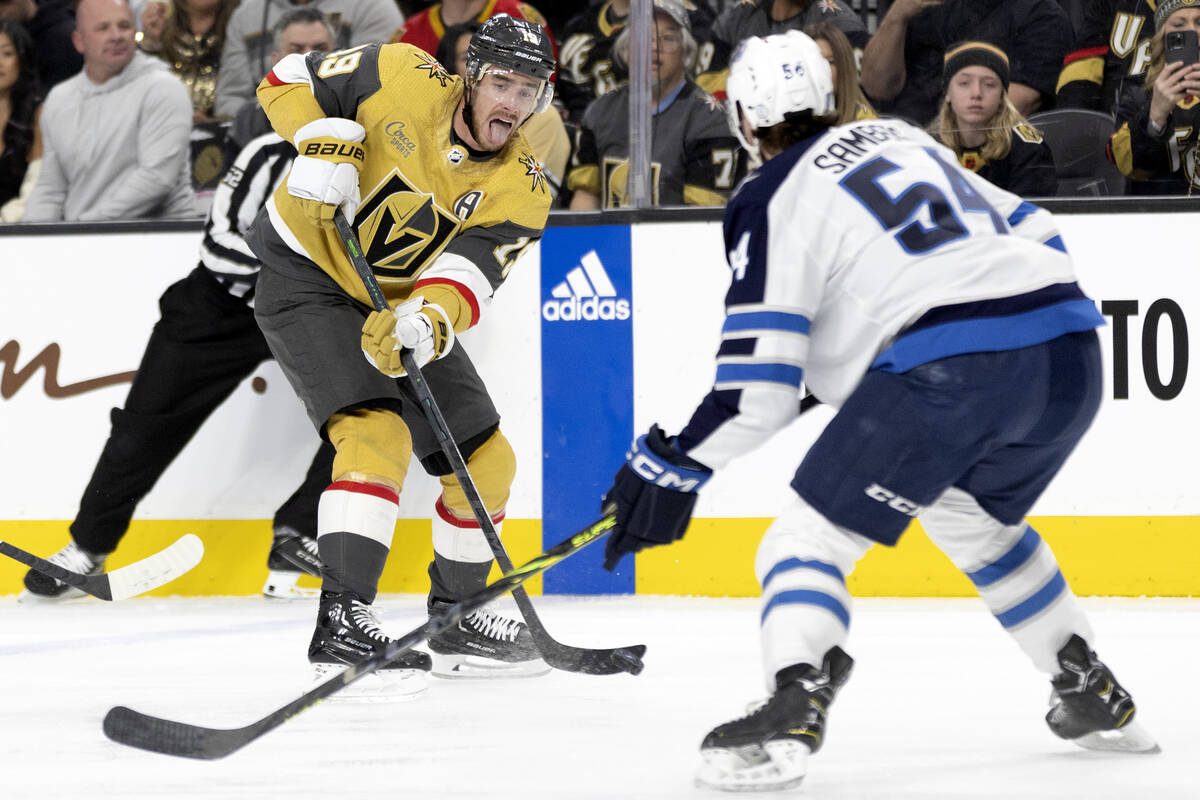 Golden Knights right wing Reilly Smith (19) passes while Jets defenseman Dylan Samberg (54) gua ...