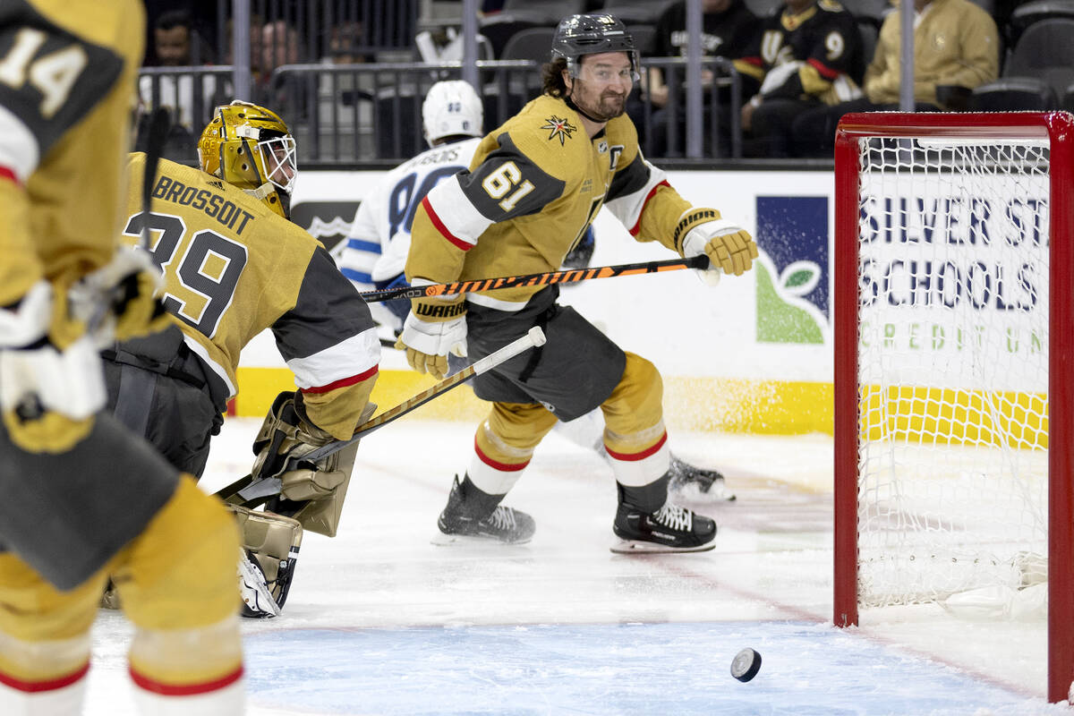 Golden Knights goaltender Laurent Brossoit (39) misses a save while right wing Mark Stone (61) ...