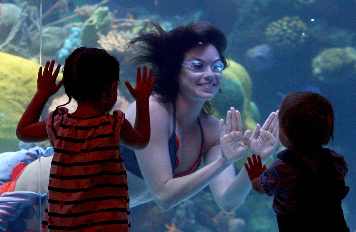 Rachel Simon, one of the mermaids at the Silverton hotel-casino, smiles at Rebekah Tomiz, 3, le ...