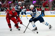 Detroit Red Wings center Joe Veleno (90) knocks the puck from Winnipeg Jets defenseman Nate Sch ...