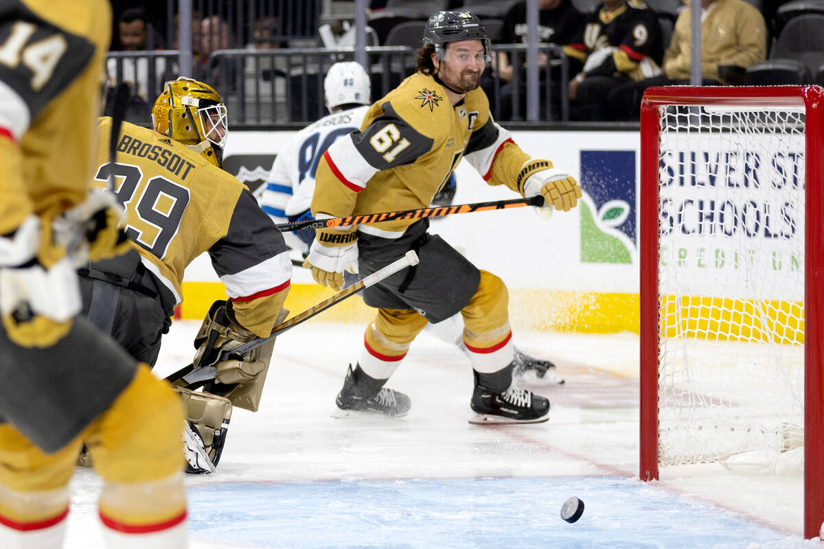 Golden Knights goaltender Laurent Brossoit (39) misses a save while right wing Mark Stone (61) ...