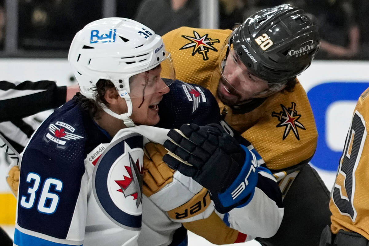 Vegas Golden Knights center Chandler Stephenson (20) helps Winnipeg Jets center Morgan Barron ( ...