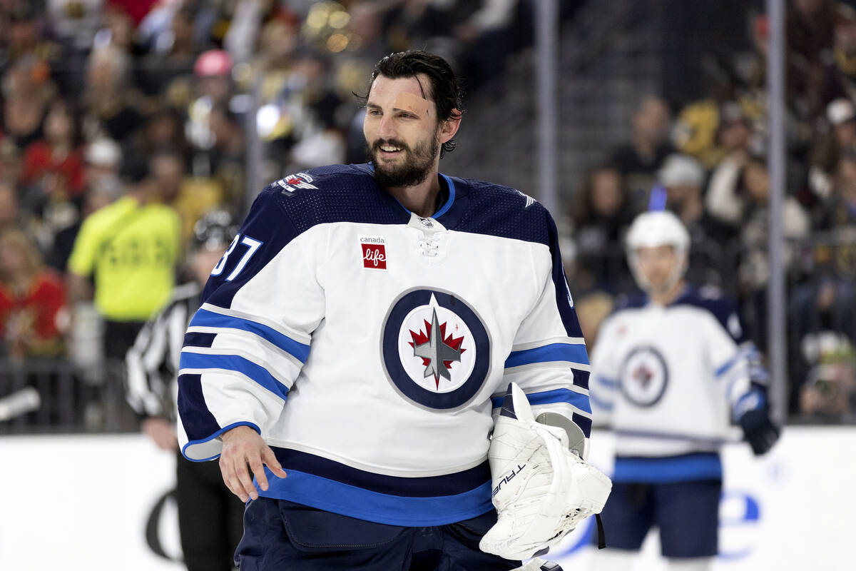 Winnipeg Jets goaltender Connor Hellebuyck (37) returns to the ice with his face bandaged durin ...