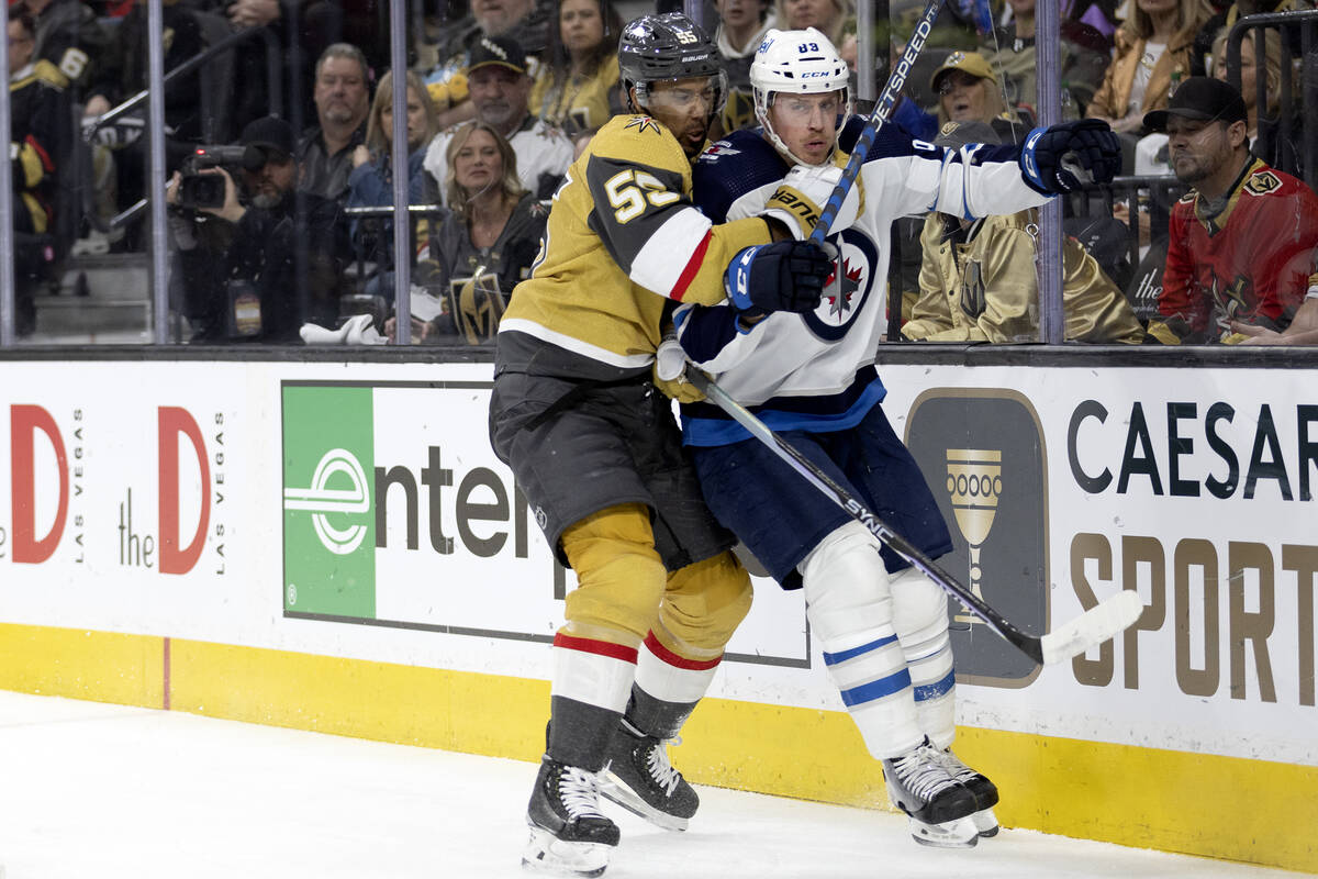 Golden Knights right wing Keegan Kolesar (55) slams Winnipeg Jets defenseman Nate Schmidt (88) ...