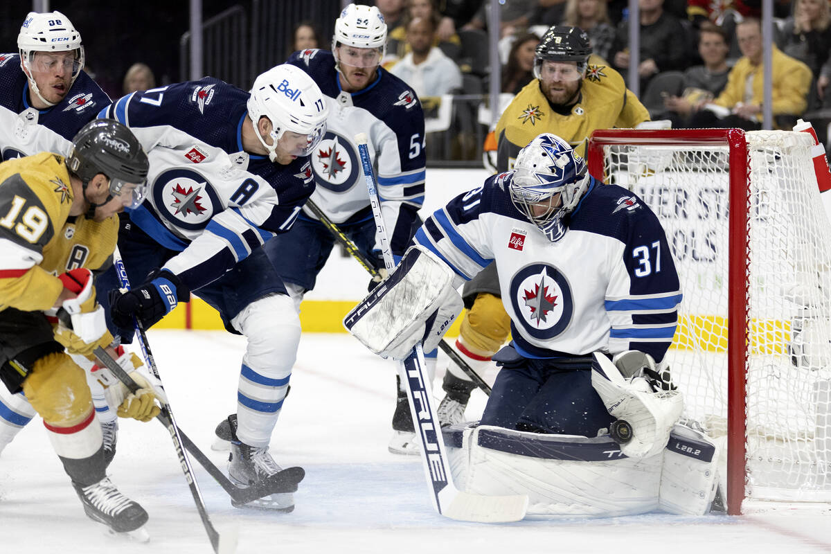 Golden Knights right wing Reilly Smith (19) shoots while Winnipeg Jets goaltender Connor Helleb ...