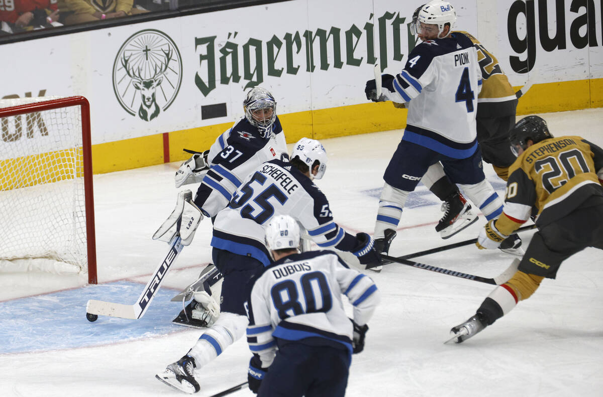 Golden Knights center Chandler Stephenson (20) scores a goal against Winnipeg Jets goaltender C ...