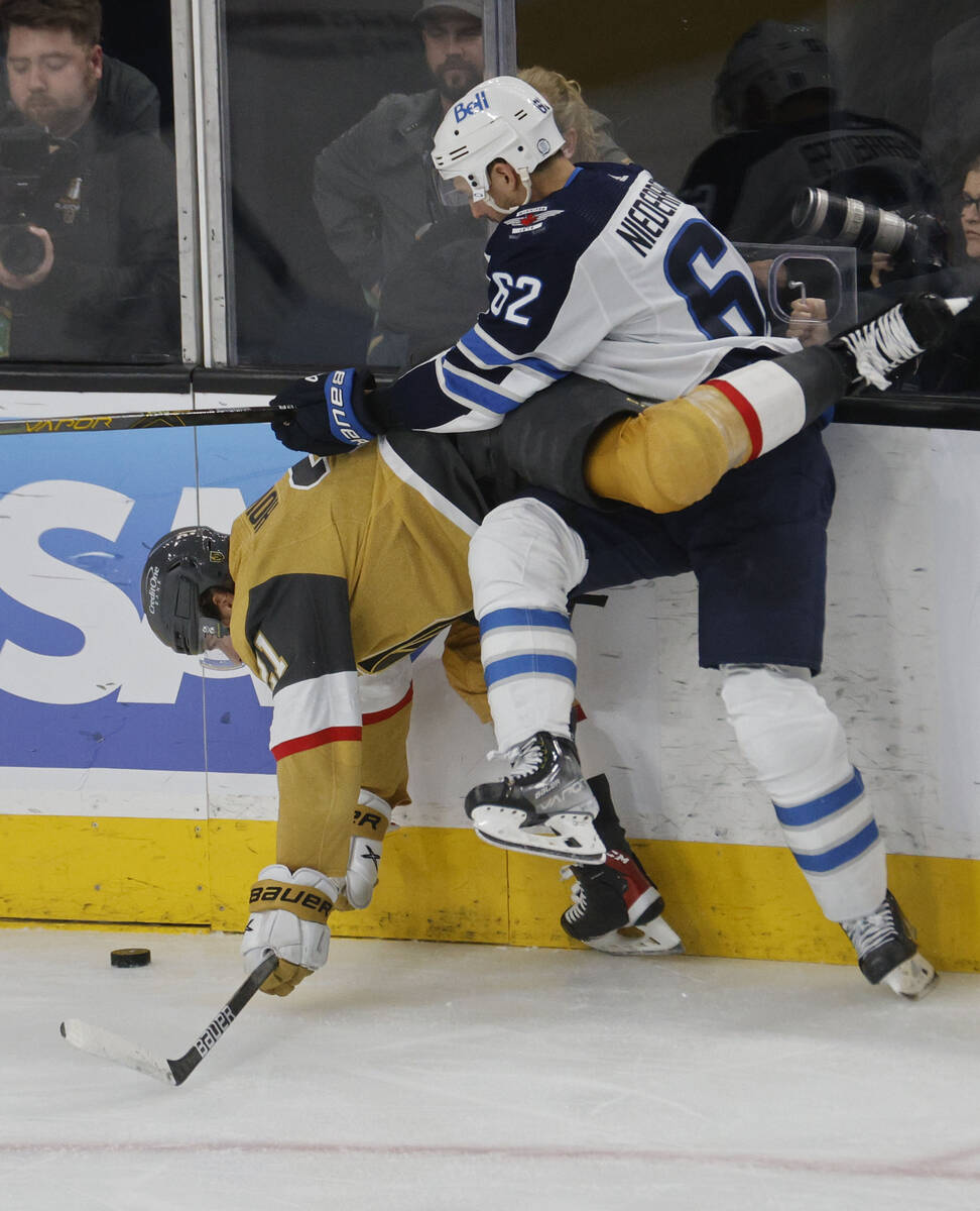 Golden Knights center Brett Howden (21) tangles with Winnipeg Jets right wing Nino Niederreiter ...