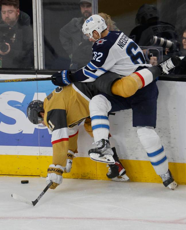 Golden Knights center Brett Howden (21) tangles with Winnipeg Jets right wing Nino Niederreiter ...