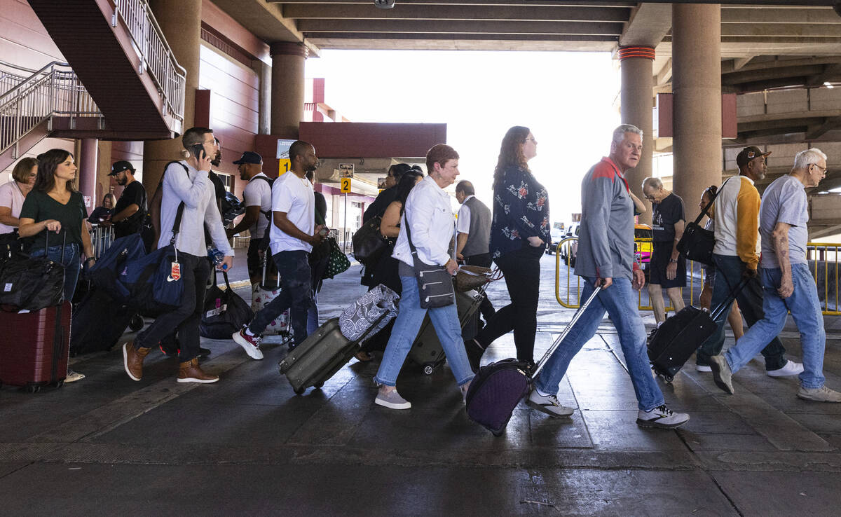 Arriving passengers head to the parking garage and Ride Share pickup location in Terminal 1 of ...