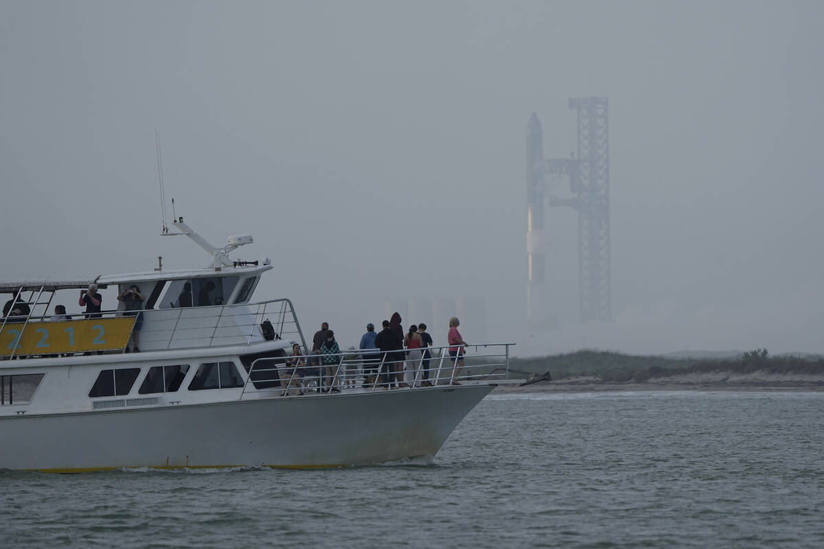 A tour boat passes SpaceX's Starship, the world's biggest and most powerful rocket, was it prep ...