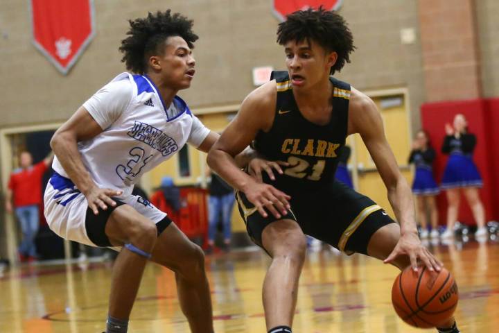 Clark's Jalen Hill (21) moves the ball around Desert Pines' Jamir Stephens (33) during the seco ...