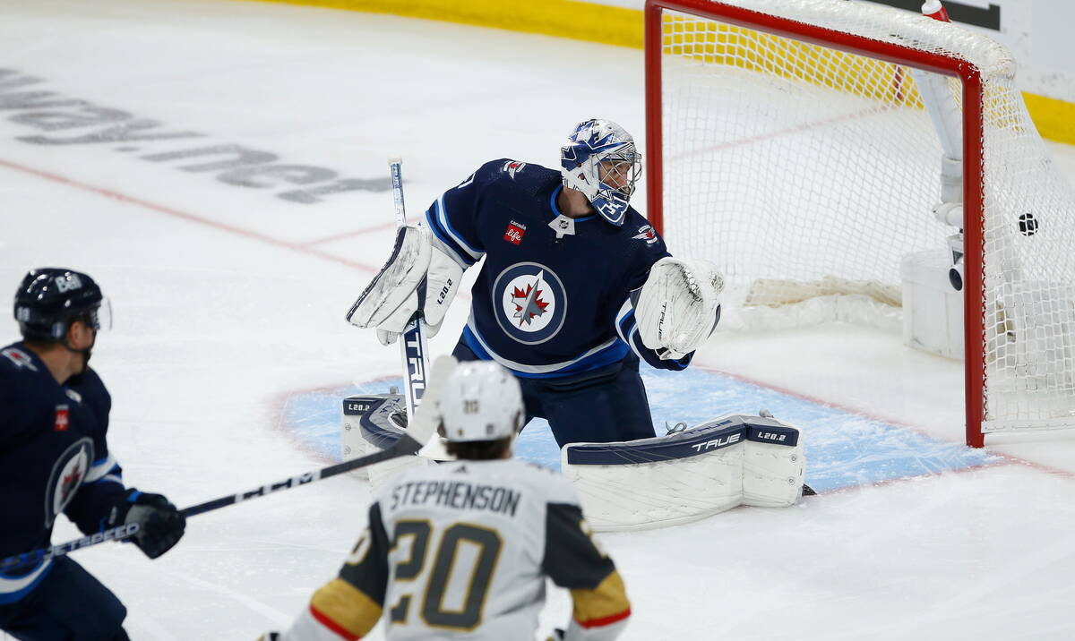 Vegas Golden Knights' Chandler Stephenson (20) scores on Winnipeg Jets goaltender Connor Helleb ...