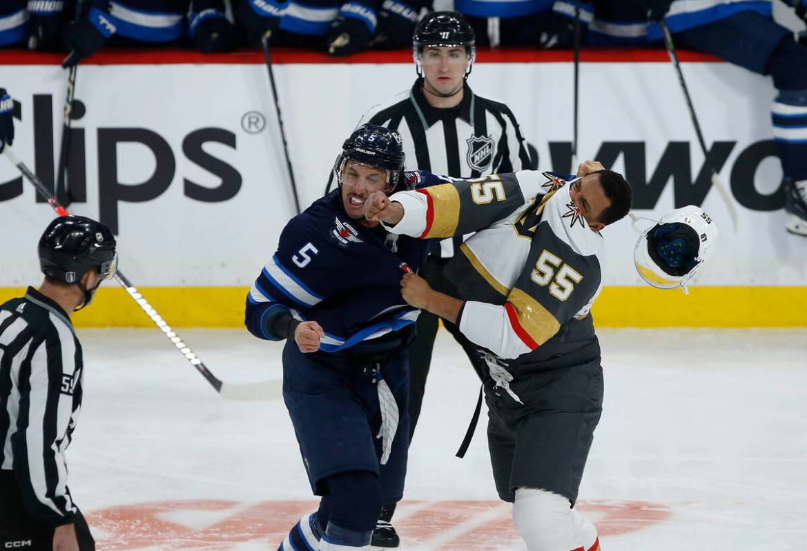 Winnipeg Jets' Brenden Dillon (5) and Vegas Golden Knights' Keegan Kolesar (55) fight during th ...